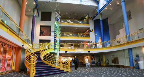 The Children's Museum of Indianapolis interior with staircase and people walking around.