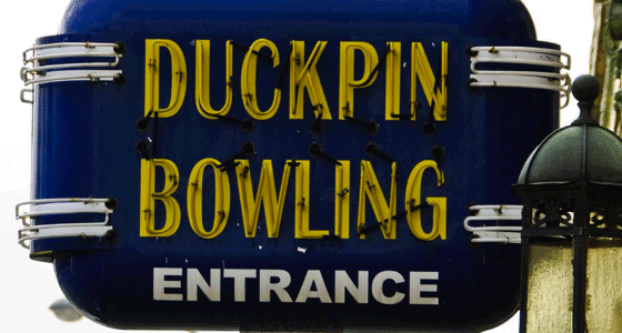 An old neon sign advertising duck pin bowling on the side of the Fountain Square building.